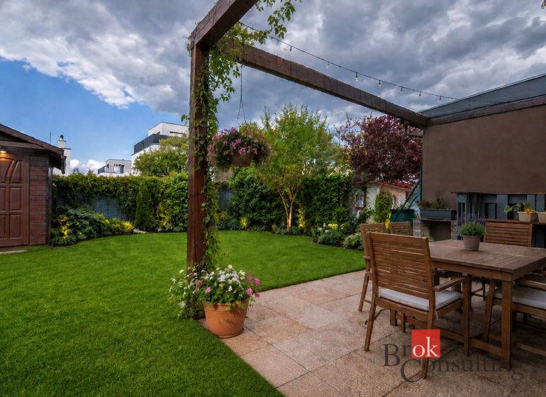 The garden of a family house on Kapsohradská in Bratislava-Záhorská Bystrica with a wooden pergola.