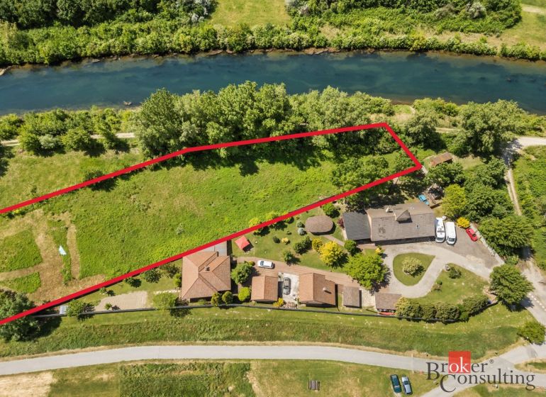 Aerial view of recreational plots in Hamuliakovo by the river, surrounded by greenery.