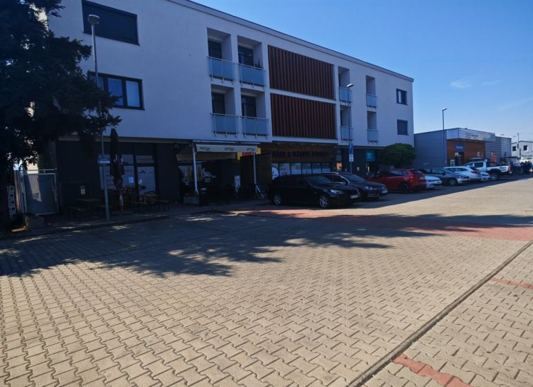 The building on Senická Street in Rohožník with parking spaces in the foreground.