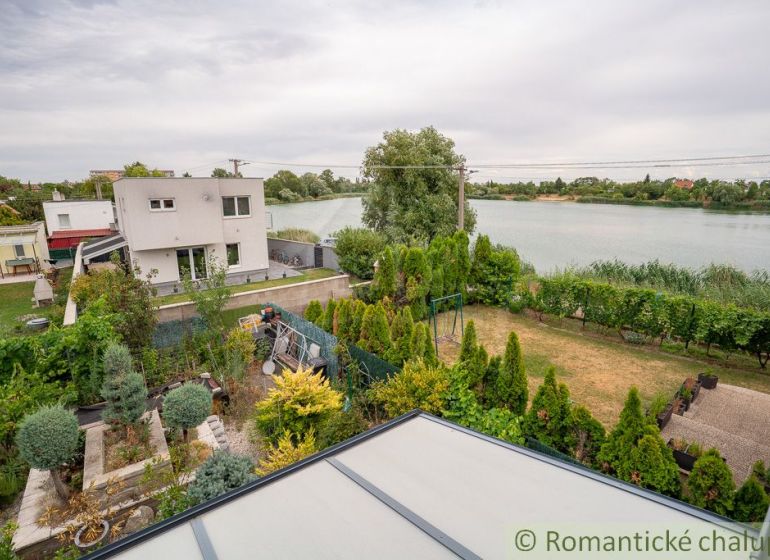 View from the cottage by the lake in Senec, surrounded by a lush garden.