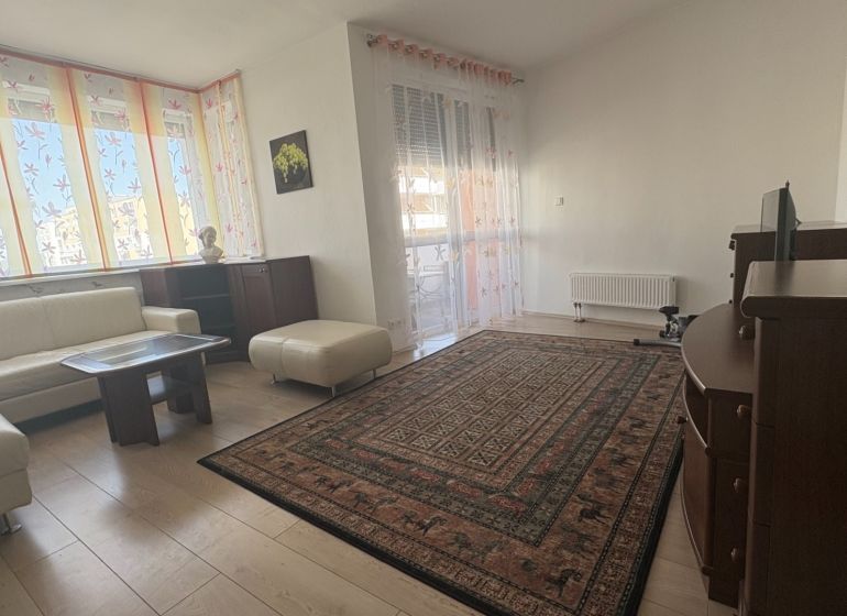 Living room with a sofa set, table, and wooden decor flooring.