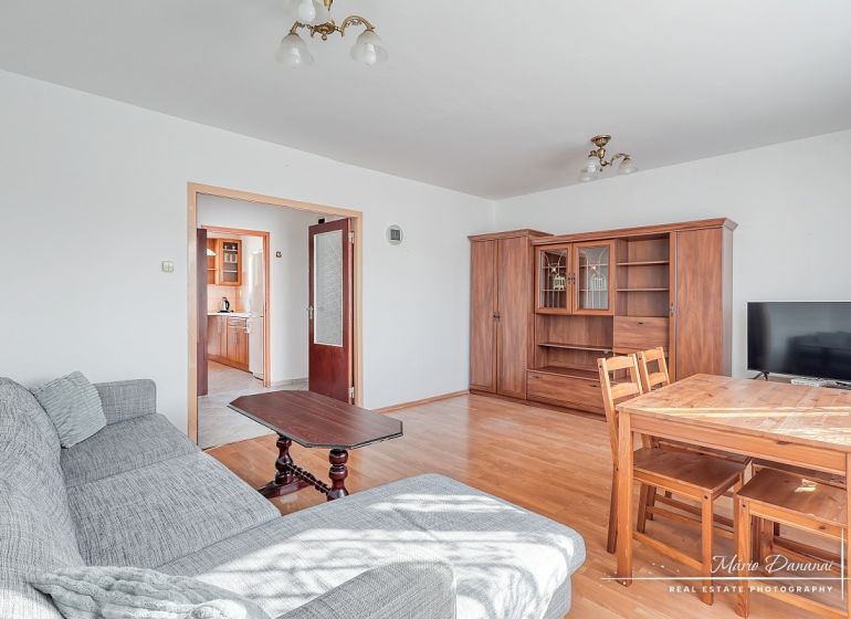 Living room in a three-room apartment with a wooden decor floor and furniture.