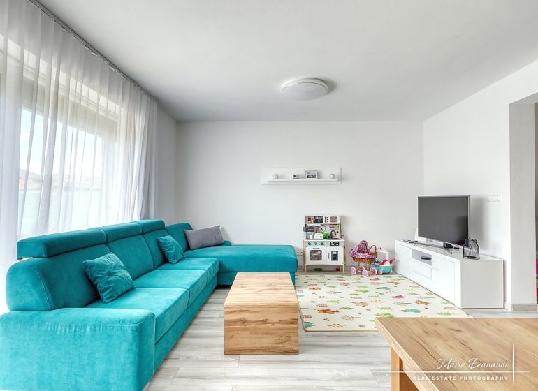 Living room in a family house with a turquoise sofa, television, and children's toys on Lipova Street.