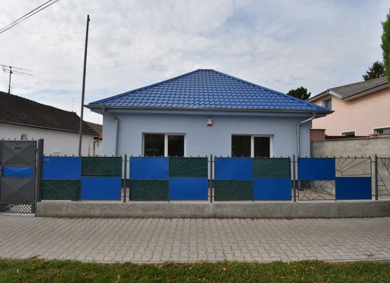 The exterior of commercial premises on Dlhoveská Street in Šaľa with a blue roof and fence.