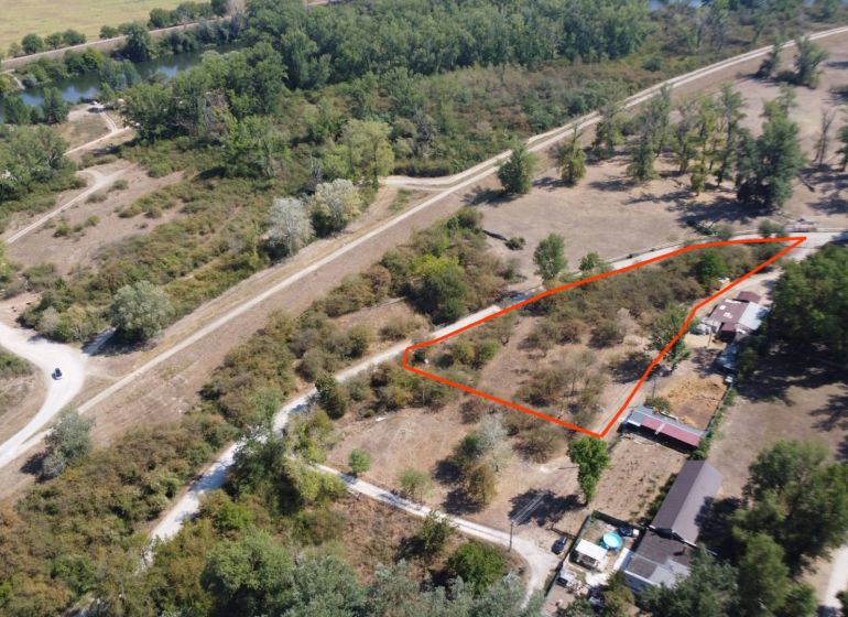 Aerial view of recreational lands by the river in Piešťany, lined with trees.