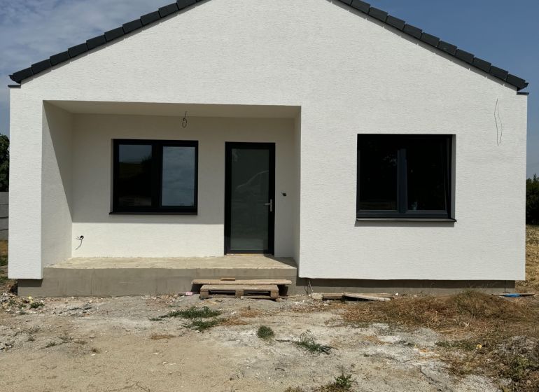 A family house in Suchá nad Parnou with a sloping roof and a light facade.