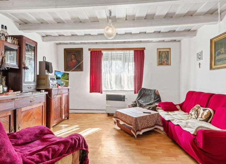 Living room in a family house with a wooden decor floor and red seating.