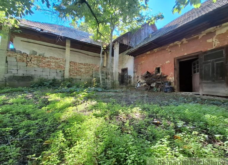 An older house with a garden and a crumbling facade in Nová Vieska, suitable for residential land.