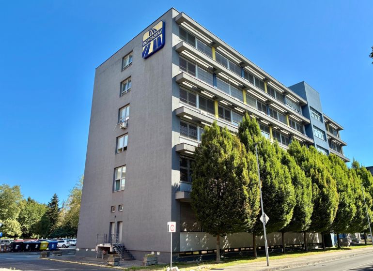 An office building with several floors and trees in Bratislava - Ružinov.