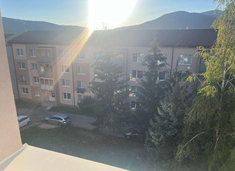 A view of apartment buildings in Rožňava with a view of greenery and mountains.