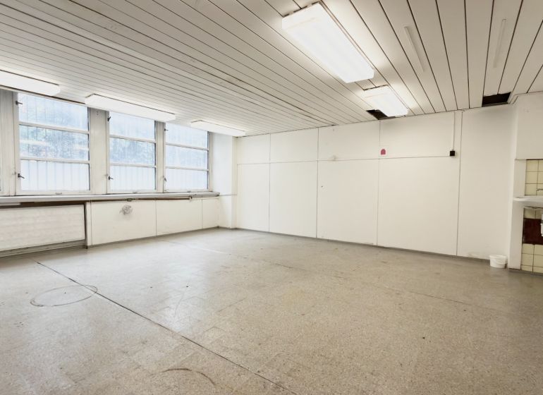 A bright room with four large windows and a sink, suitable for storage and halls.