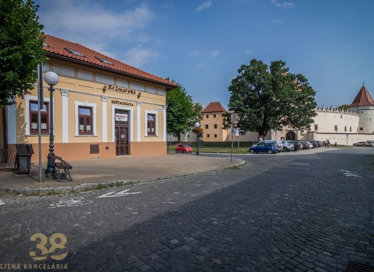 A restaurant on the Castle Square in Kežmarok with a view of historical buildings.