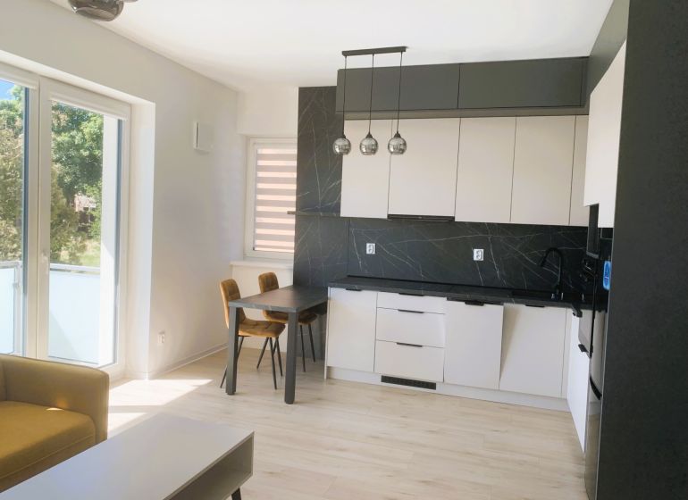 A bright kitchen with a wood-patterned floor in a 3-room apartment.