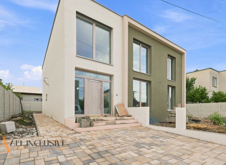 A family house in Holice with a light facade and a paved courtyard.