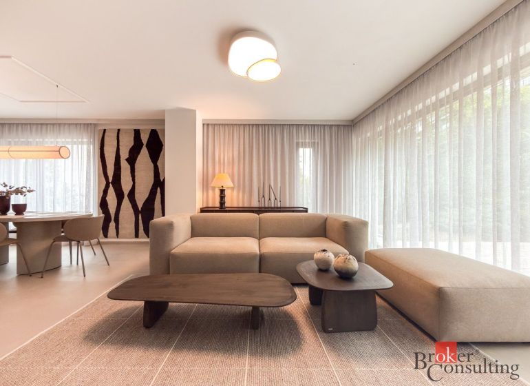 Living room in a 4-room apartment with a wooden decor floor, light furniture, and decorations.