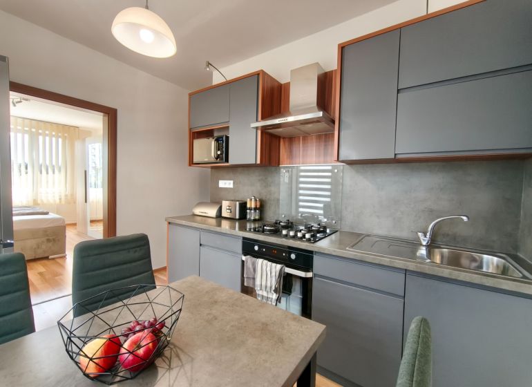 A kitchen in a 3-room apartment with a dining table and a modern kitchen unit.