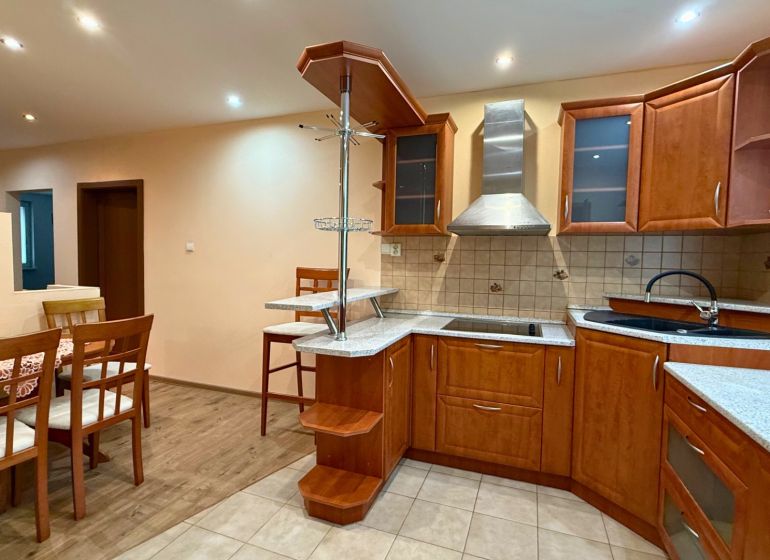 A kitchen with wooden decor and a dining table in a 3-room apartment.