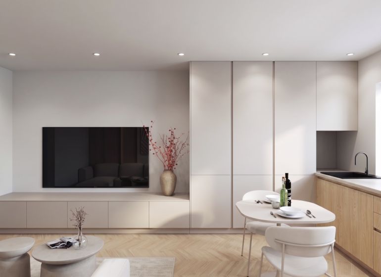 Living room in a two-room apartment, with a TV, dining table, and wooden decor flooring.