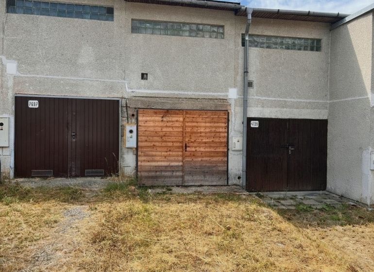 Garages on Môťová Street in Zvolen with concrete facades and wooden gates.