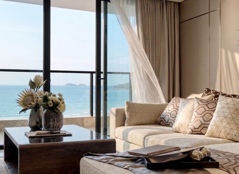 Living room in a 3-room apartment with a view of the sea and a wooden decor floor.