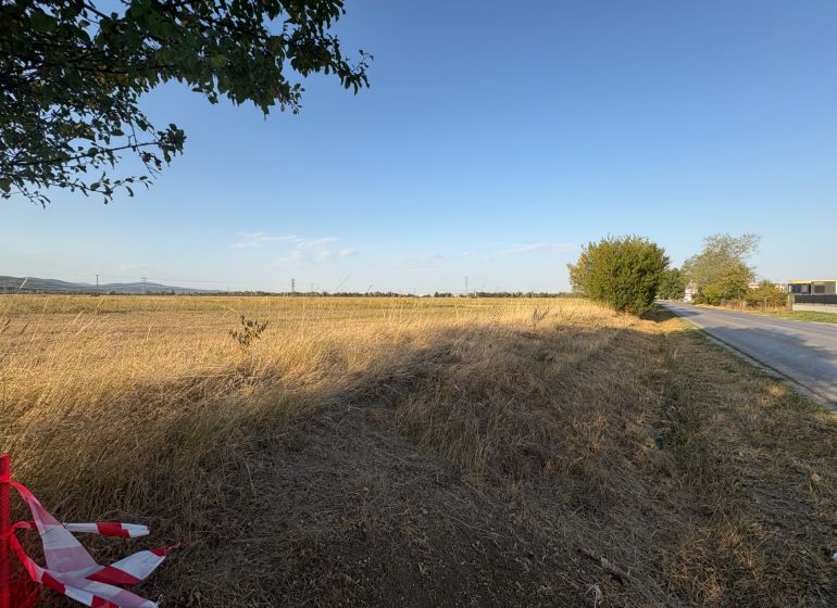 Commercial land on Šenkvická Road in Pezinok with an extensive meadow and sky.
