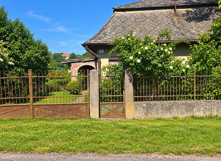 A family house in Ľuba at the address Ľubá 143 with an ornamental garden and flowers.