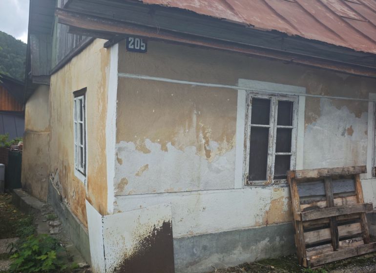 A family house in Špania Dolina with an older facade and a sloped metal roof.
