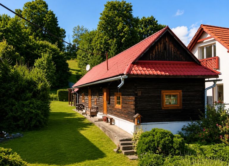 A cottage in Beňadiková with a red roof surrounded by greenery and trees.