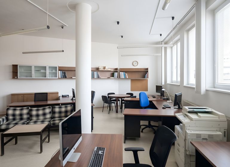Offices with wooden decor furniture, desks, and computers.