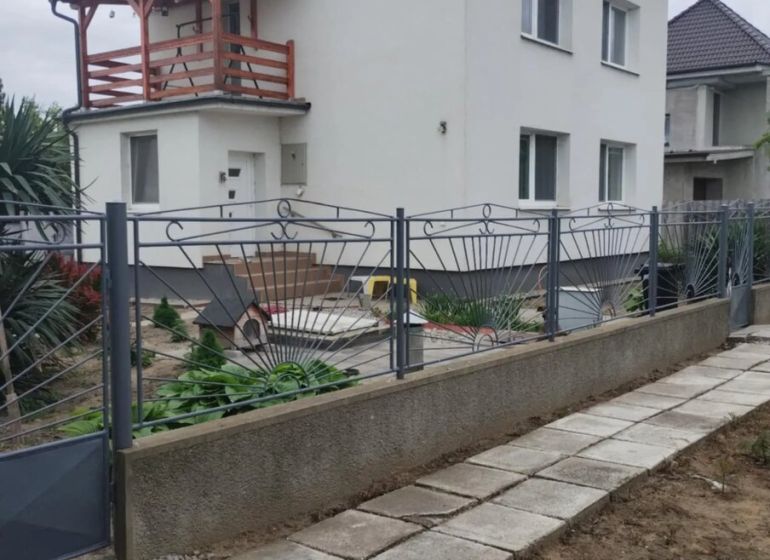 A family house in the city of Trnava with a white facade and a wooden balcony.