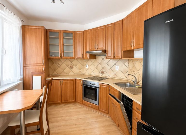 Kitchen in a 3-room apartment with a wooden decor countertop and floor, swivel table.