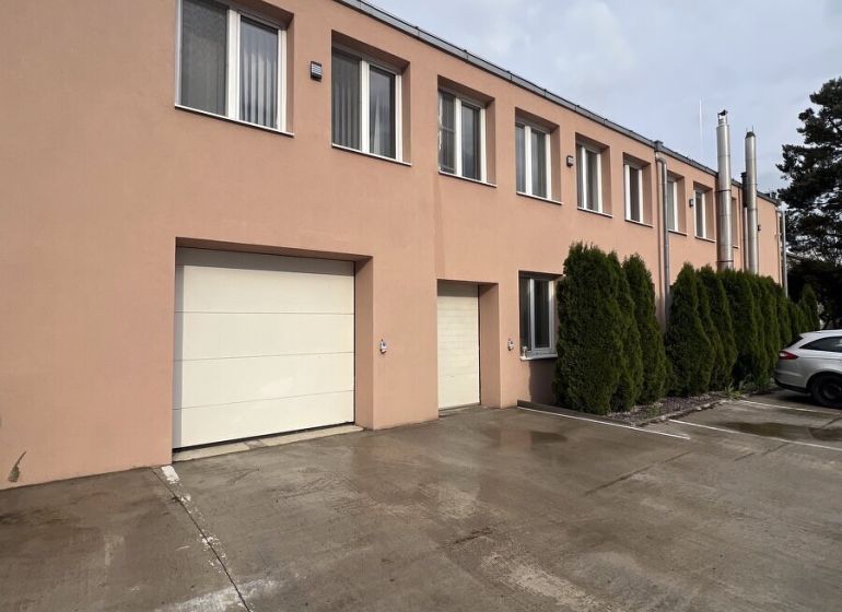 Warehouses and halls in Veľký Šariš with a concrete access road and garage doors.