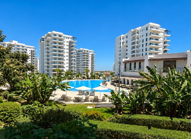Apartments in Bogazi surrounded by greenery with a pool in the center.