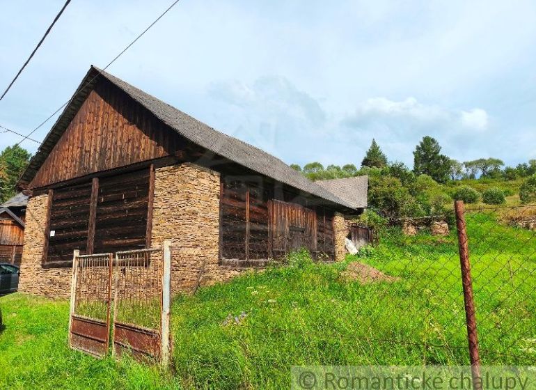 An old wooden house surrounded by greenery suitable for residential land in Nižné Repaše.