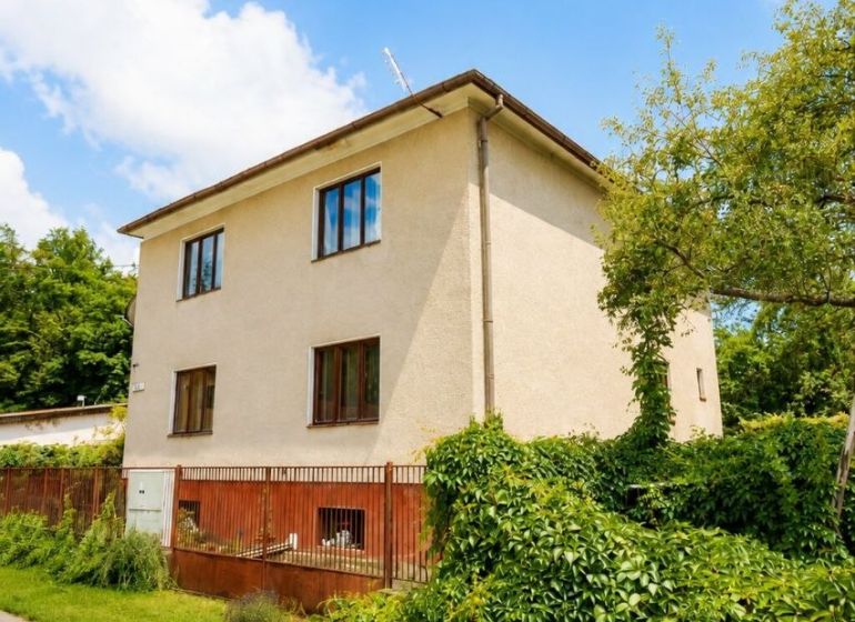 A family house on Pod Laščeky Street in Žilina, surrounded by green vegetation.
