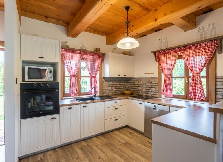 A kitchen in a family house with a brick wall and a wooden decor floor.