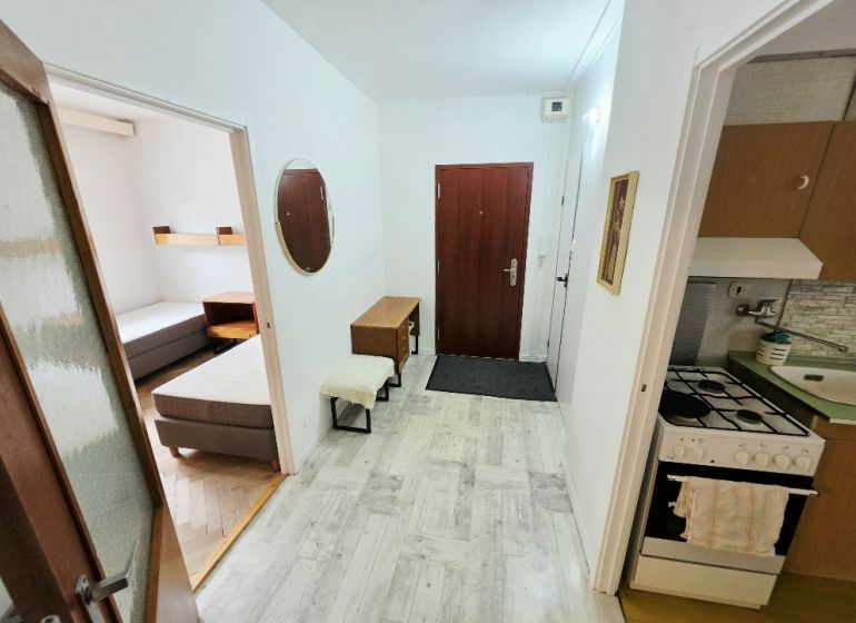 Entrance hall of a 3-room apartment with a kitchenette and a view into the bedroom.