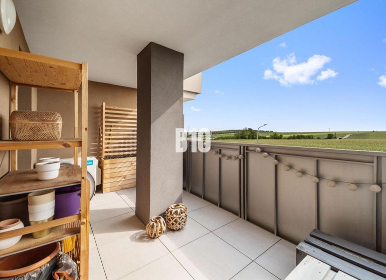 A balcony in a 4-room apartment in Nitra with a view of the surrounding countryside.