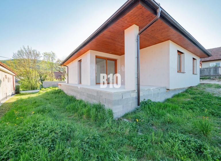 A family house in Nitra with a concrete terrace and a green lawn in the garden.