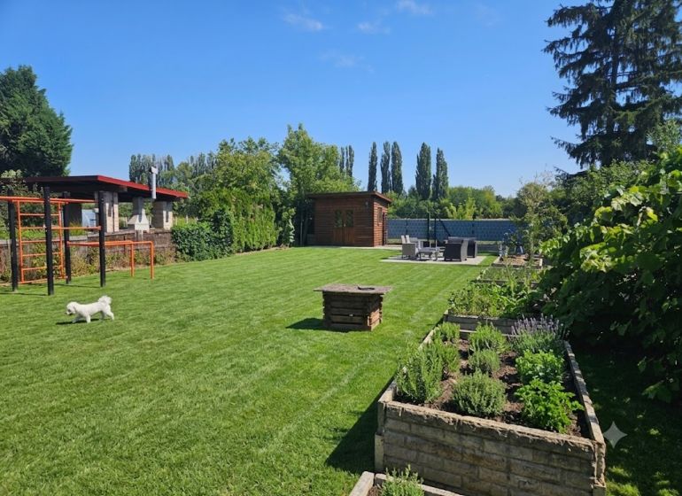 Garden in Kamenný mlyn, Trnava with a green lawn and raised beds.