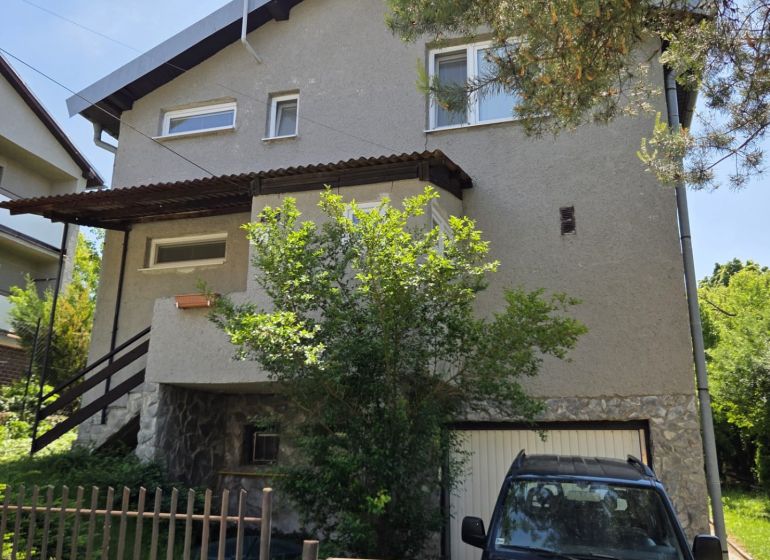 A family house in Nižná Hutka with a garden and a garage, surrounded by greenery.