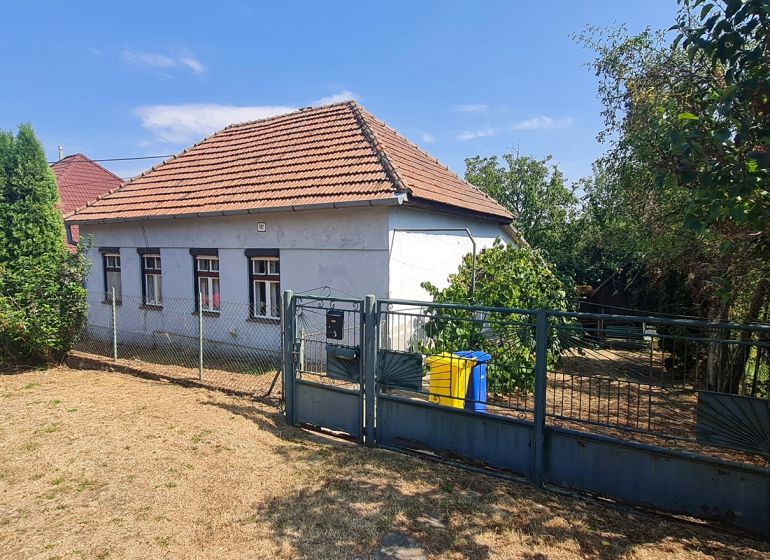 A family house in Dolné Otrokovce with a fence and a garden on a sunny plot.