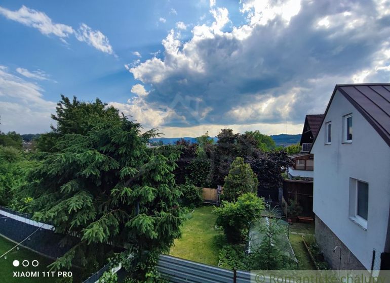 A family house in Banská Bystrica with a large garden, surrounded by greenery and trees.