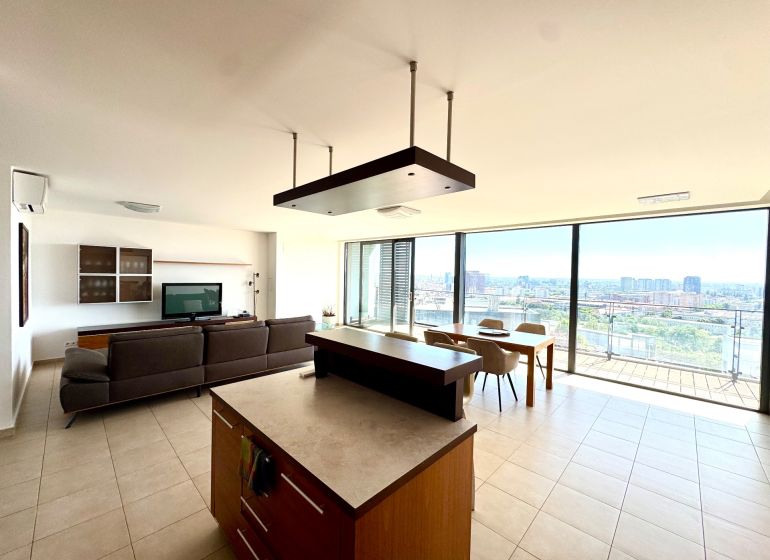 A spacious living area with a kitchen and dining room in a 4-room apartment with a panoramic view.