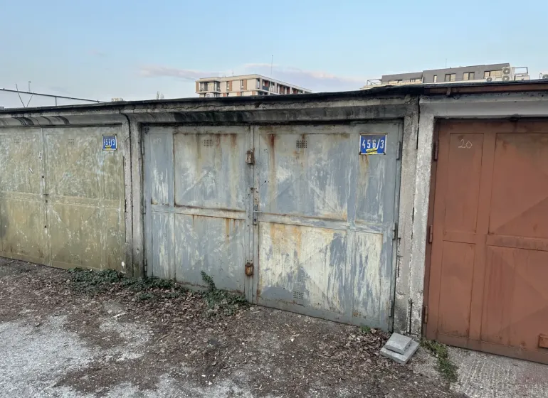 Abandoned garages in Bratislava - Nové Mesto with peeling plaster and metal doors.