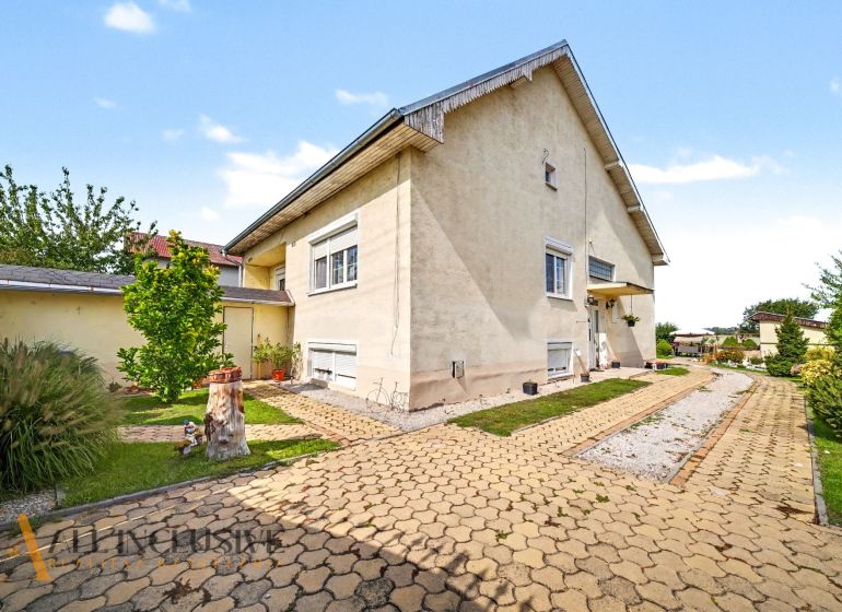 A family house on Vojtechovce Street in Nový Život is surrounded by a well-maintained garden with a walkway.