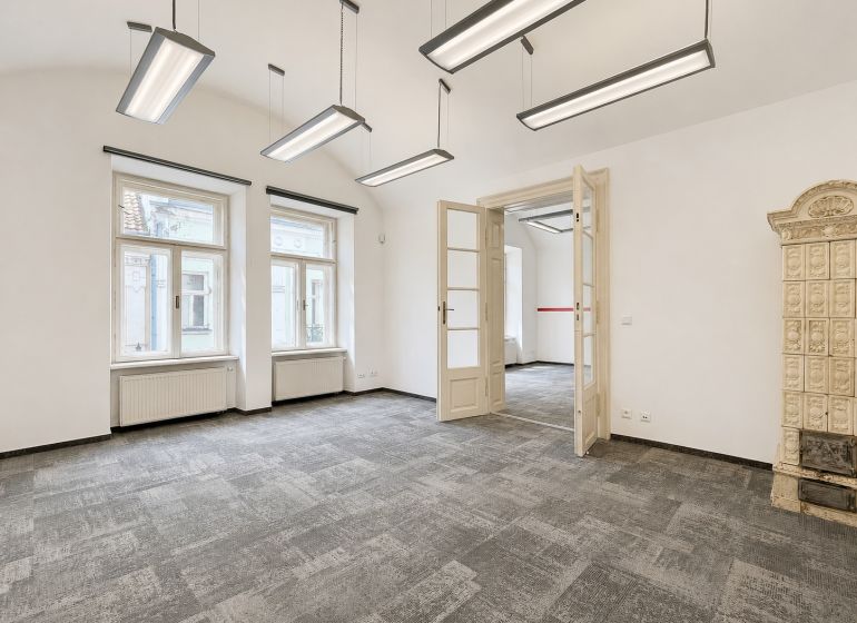 Offices with a tiled stove and pendant lights, floor with wooden decor.