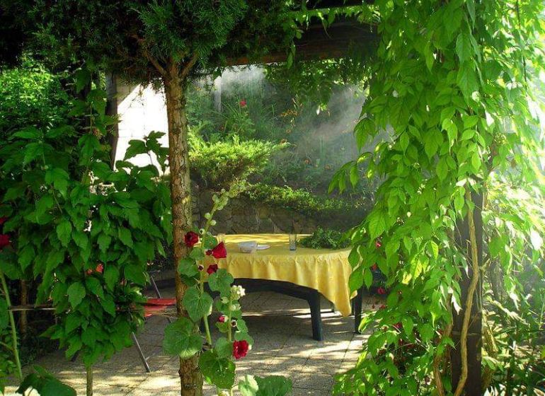 Garden seating by the cottage in Žilina, surrounded by greenery and flowers.