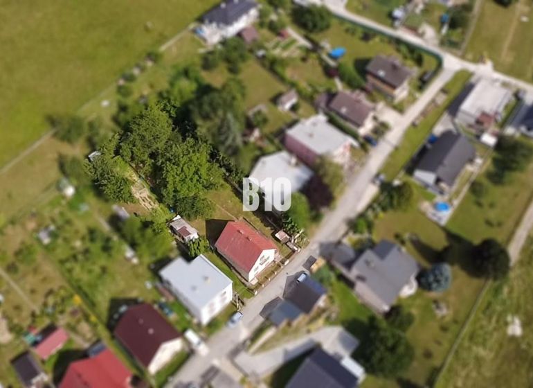 Aerial view of a family house in Považská Bystrica surrounded by greenery and other houses.