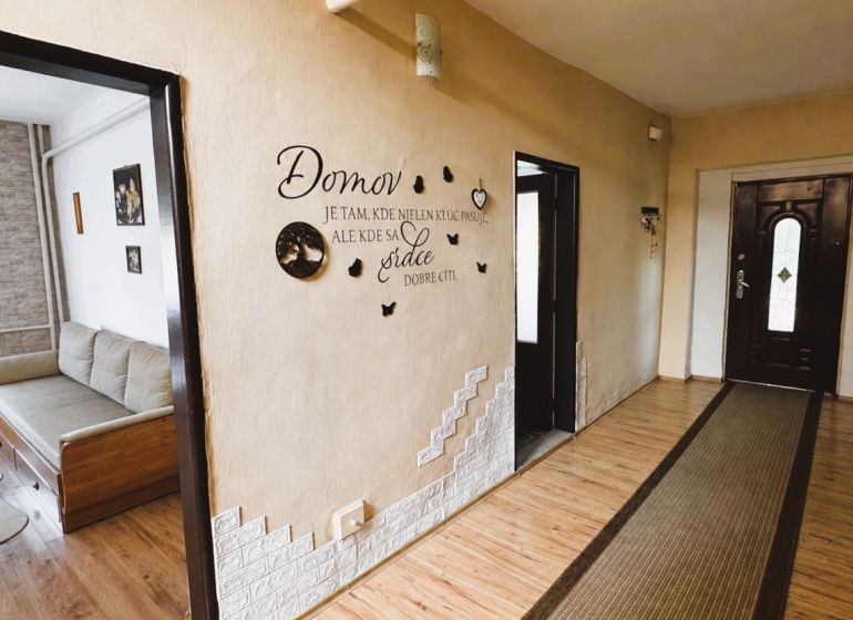 A hallway in a family house with wall decorations and a wooden decor floor.